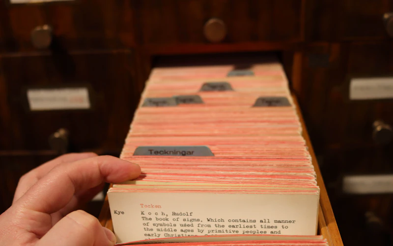 A reader consulting a library card catalog