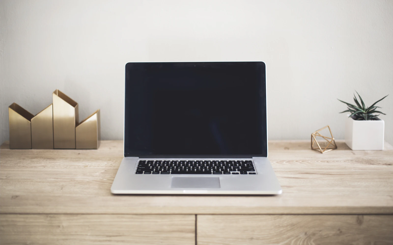 Laptop on a simple wooden desk in natural light